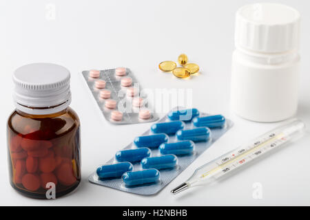 Medical setup of glass and plastic bottles for medicine and a thermometer Stock Photo