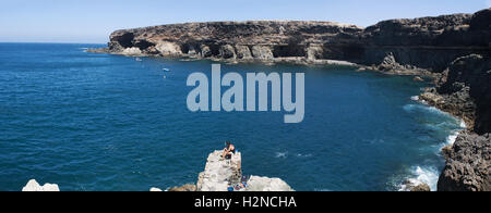 Fuerteventura, Canary Islands, North Africa, Spain: a fisherman seated on a rock in front of the famous caves of Ajuy, a little village of the west Stock Photo