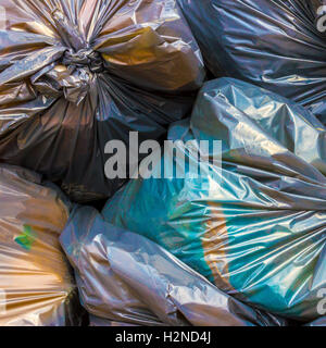 Pile of Full Garbage Bags. Pile of green garbage bags tied up tightly,  placed on the ground in the street Stock Photo - Alamy