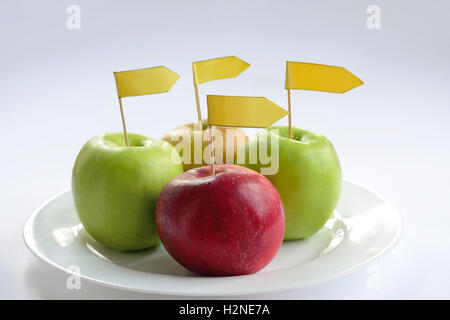 four apples with label on a plate Stock Photo