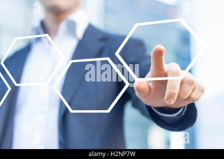Businessman touching hexagonal button in workflow with honeycomb pattern Stock Photo