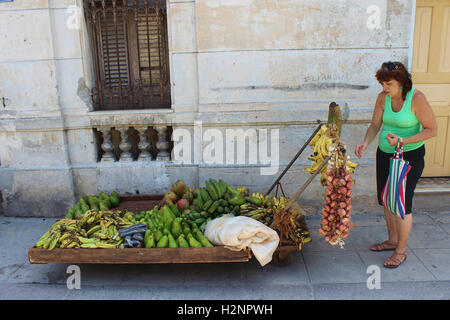 Local Cuban woman buying fruit & vegetables in a Havana street. traditional Cuba. Taken in July, Authentic Cuban experience Stock Photo