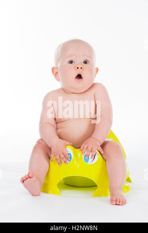 Baby, ten months, sitting on a potty Stock Photo