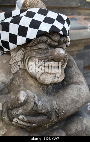 Indonesia, Bali, Sidemen, figure outside, Hindu temple wrapped in Saput poleng black and white checkered cloth Stock Photo