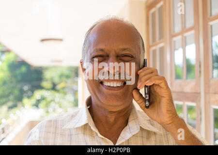 Closeup portrait, happy bald pensioner enjoying phone conversation. Call me on my cell phone, isolated outdoors outside Stock Photo