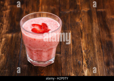 Strawberry milk smoothie in a glass, wooden background Stock Photo