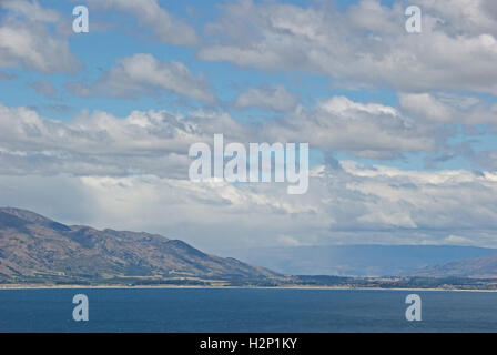 Several layers of clouds create a dramatic view over Lake Hawea on New Zealand's South Island. Stock Photo