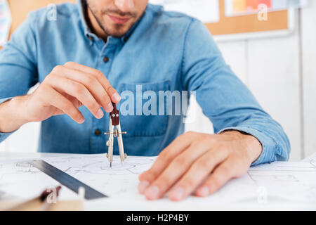 Cropped image of a architect working on construction blueprint in office with divider at office Stock Photo