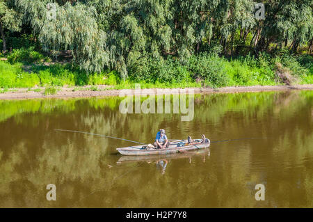 A fisherman in a wooden boat on the Desna river in the vicinity of Chernihiv, Ukraine. Stock Photo