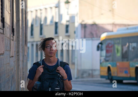 Man walking in the street with backpack. Lisbon, Portugal Stock Photo