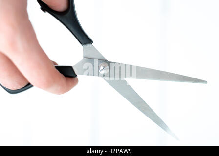 the hand holds the scissors for thinning out on an isolated white background Stock Photo