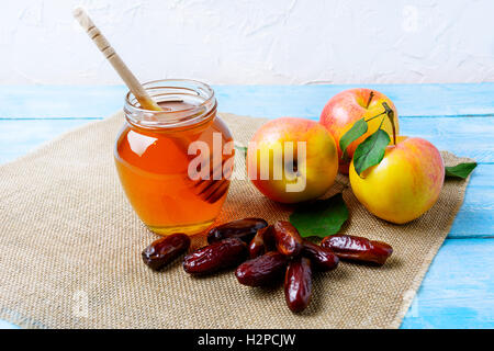 Honey jar, dates and apples on burlap napkin. Rosh hashanah concept. Jewesh new year symbols. Stock Photo