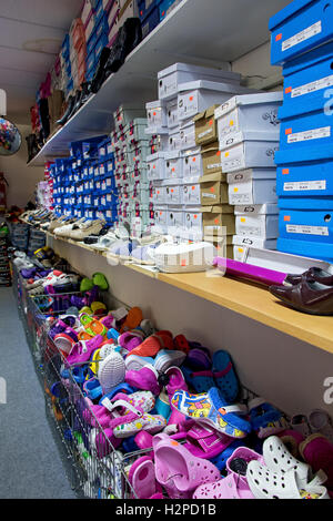 Shoes with boxes on the shelves in the store Stock Photo