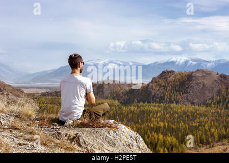 Man yogi meditating in the mountains Stock Photo