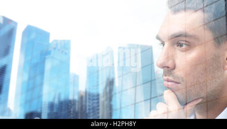 close up of male face over office buildings Stock Photo
