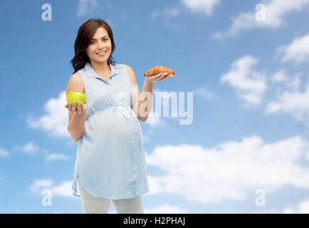 happy pregnant woman with apple and croissant Stock Photo