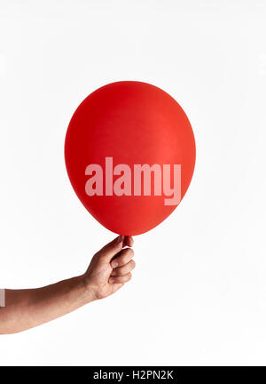Man holding red balloon on white background Stock Photo