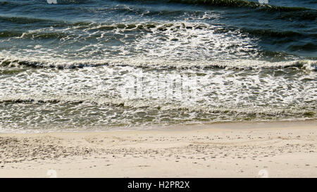 Foamy waves rolling up onto white sand beaches of Perdido Key. Stock Photo