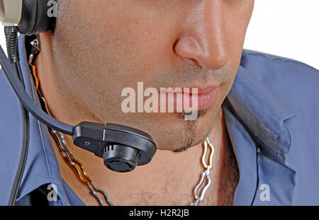 A closeup head shot of a young man with a headset in a blue shirt. Stock Photo