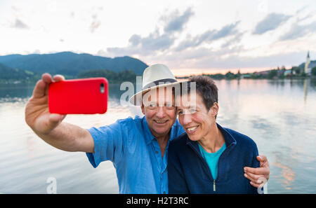 Man and woman smiling, taking photo with mobile phone, selfie, Schliersee, Upper Bavaria, Bavaria, Germany Stock Photo