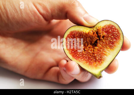 Hands holding figs in heart shape close up isolated beautiful photo Stock Photo