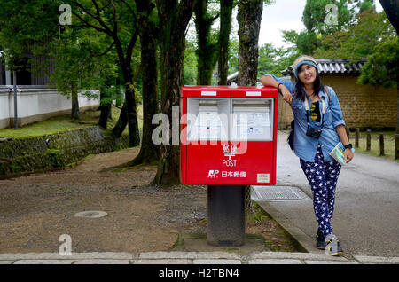 Traveller thai woman portrait with red post box in garden of Todai-ji Temple at Kansai region on July 9, 2015 in Nara, Japan Stock Photo