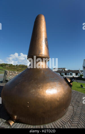 Isle of Islay, Scotland. Picturesque view of a whisky pot still, with the Ardbeg whisky distillery in the background. Stock Photo