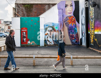 Sun, Spray and Art Festival Art in East Topping street, Blackpool, Lancashire, UK. Pedestrian walking past street art, graffiti wall painting, decoration. Stock Photo