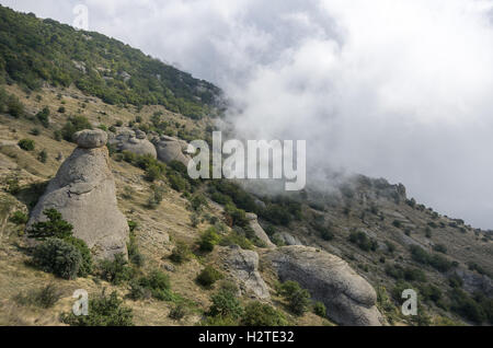 Low clouds on slope of the Demerdji mountain. The rock formations in Valley of Ghosts. Landscape of Crimea, Russia. Ukraine Stock Photo