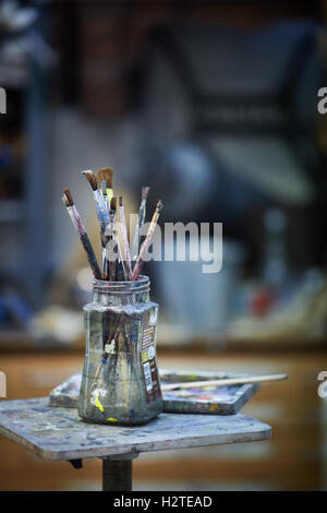 Artist brushes jam jar used paint painting    School college night class learning teaching creative arts drawing canvas still li Stock Photo