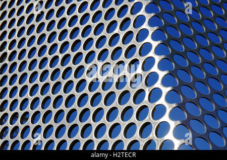 Aluminum perforated grid against a blue sky under sun light Stock Photo