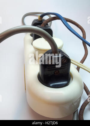 Vintage socket outlet extension cord. All the connectors are engaged with various devices and cables Stock Photo