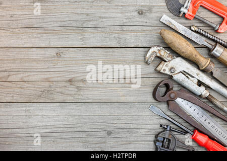 old rusty nippers, clamps wrenches and other hand tools and working instruments on wooden plank surface background Stock Photo