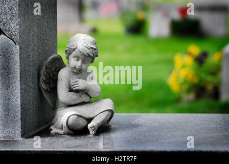 Cherub angel statue with wings carved from granite stone religious symbol brining hope and love Stock Photo