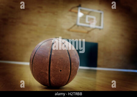 Basketball on floor of empty basketball court Stock Photo