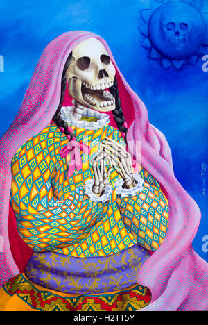 Detail of Jorge Luna painting of  a dressed skeleton. A colorful image of a female, shawl draped, skeleton clapping its hands by Stock Photo
