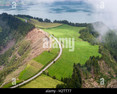 Curving Road between Lagoa Azul and Santiago. Mist moves in over a road that runs atop the crater between two volcanic lakes. Stock Photo