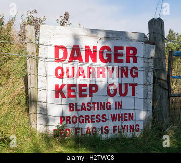 A danger blasting in progress sign above a working quarry in Frosterley, Weardale, Co. Durham, England, UK Stock Photo