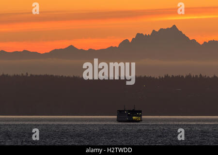 Puget Sound ferry at sunrise with Cascade mountains in background. Washington State ferries.