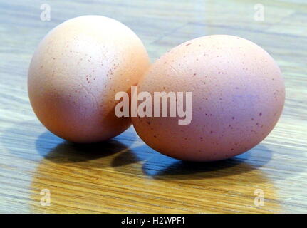 Two brown eggs on an oak table Stock Photo