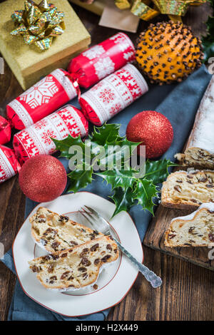 Festive Christmas cake, stollen with raisins served on table with Xmas festive ornaments Stock Photo