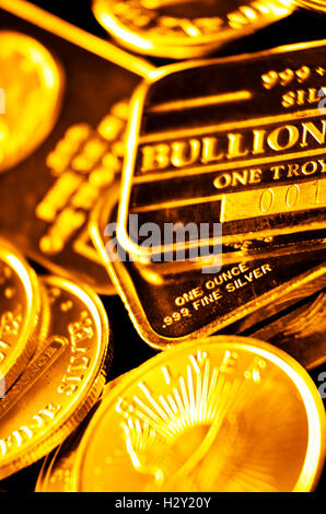 Several stacks of gold coins and bars representing wealth Stock Photo
