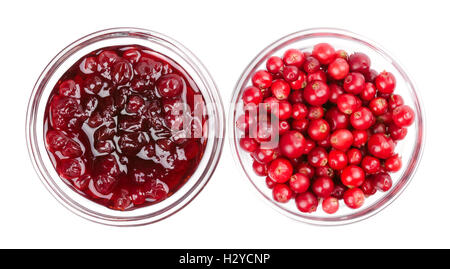 Lingonberry jam and lingonberries in glass bowls over white. Fresh red fruits of Vaccinium vitis-idaea, also mountain cranberry. Stock Photo