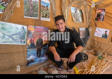 Yazd, Amir Chakhmaq Square, Tent With Soldiers and Pictures To Commemorate A Martyr, Young Man With War Photos In The Background Stock Photo