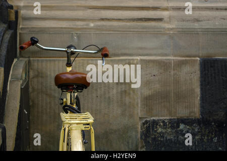 detail of old yellow bicycle. leather seat with shock absorbers and wheel Stock Photo