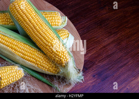 Fresh corn on cobs on rustic wooden table, closeup Stock Photo