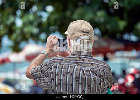Thailand tourist using a cell phone for taking photographs. Thailand S. E. Asia Stock Photo