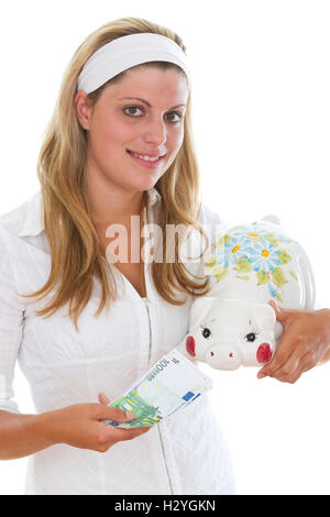 Young woman feeding a piggy bank Stock Photo
