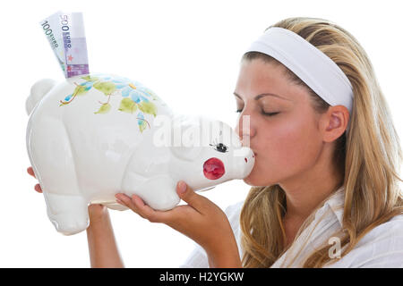Young woman kissing a piggy bank Stock Photo