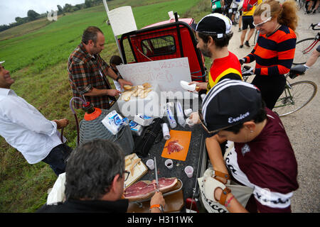 Tuscany, Italy. 2nd Oct, 2016. Cyclists buy ham sandwiches as breakfast during the 'Eroica' cycling event for old bikes in the Chianti area of Tuscany, Italy, on Oct. 2, 2016. More than 6,000 cyclists from 65 countries and regions, wearing vintage cycling jerseys, riding vintage bicycles built in 1987 or earlier, took part in the 'Eroica' (heroic) cycling event through the Strade Bianche, the gravel roads of the Chianti area of Tuscany. © Jin Yu/Xinhua/Alamy Live News Stock Photo